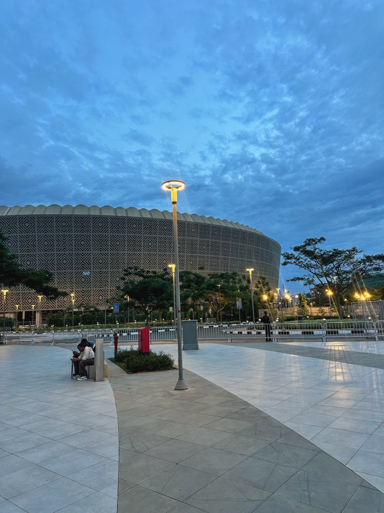 A patterned circular arena beneath a deep blue evening sky
